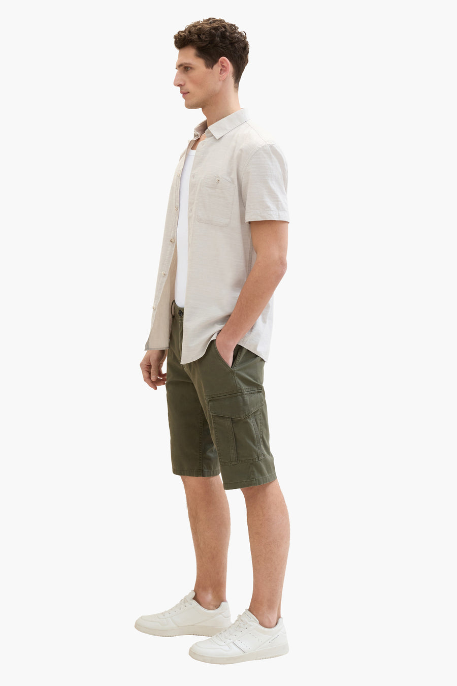 Tom Tailor bermudashorts, gedragen met een beige overhemd met knopen over een wit T-shirt en witte sneakers.