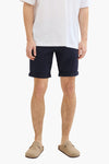 Korte marineblauwe short van Tom Tailor met omgeslagen zomen, gedragen met een wit T-shirt en suède muiltjes.