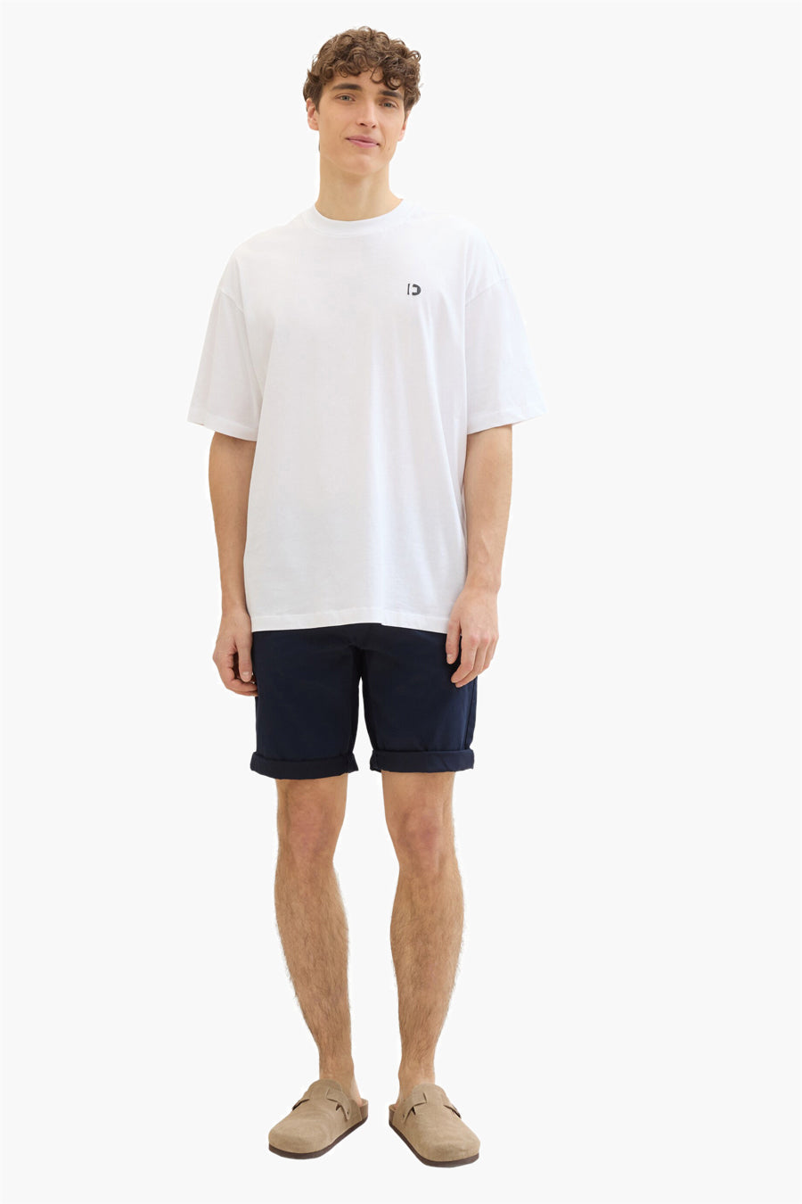 Korte blauwe Tom Tailor spijkerbroek, gedragen met een los wit T-shirt en bruine suède muiltjes.