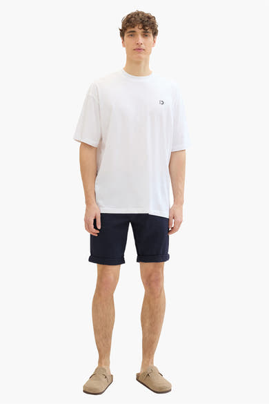Korte blauwe Tom Tailor short gedragen met een wit T-shirt en beige suède muiltjes.
