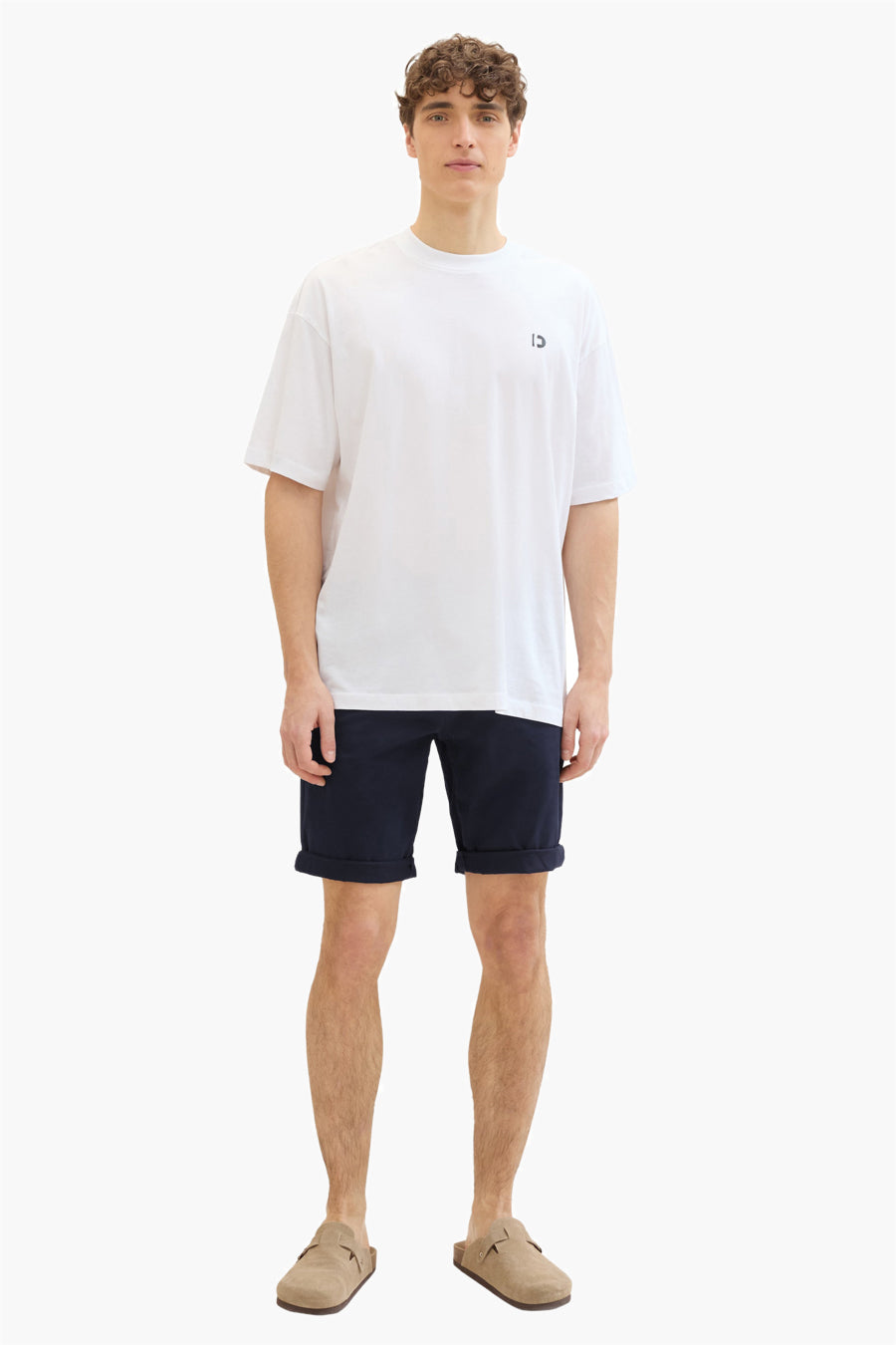 Korte blauwe Tom Tailor short gedragen met een wit T-shirt en beige suède muiltjes.