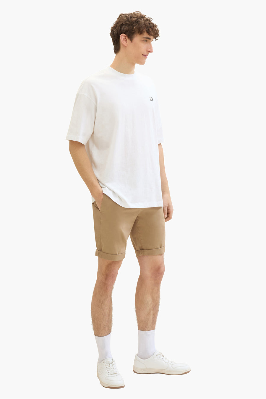 Short beige de Tom Tailor, porté avec un t-shirt blanc, des chaussettes blanches et des chaussures de sport.