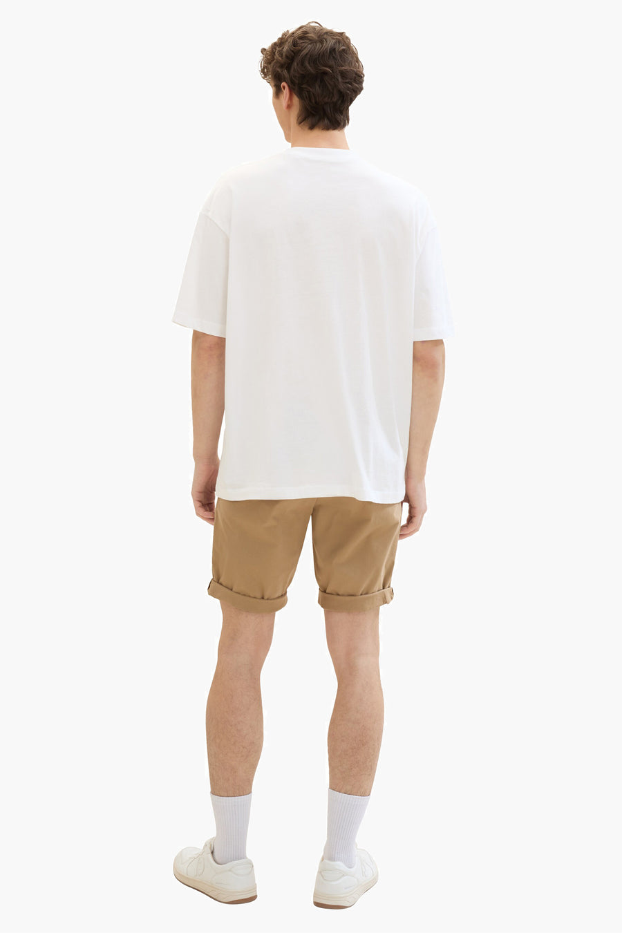Short beige de Tom Tailor, avec revers, porté avec un t-shirt blanc, des chaussettes et des chaussures blanches.