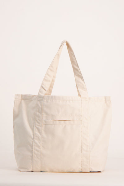 Sac à bandoulière beige de OPUS, avec une poche extérieure et des anses ton sur ton.