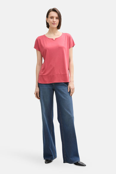 T-shirt à manches courtes rose de Tom Tailor, porté avec un jean large et des chaussures noires.