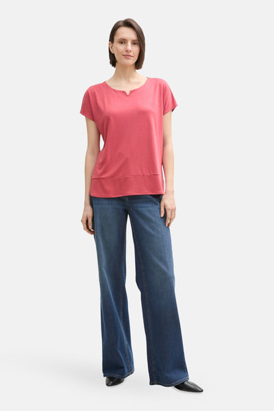 T-shirt à manches courtes rose de Tom Tailor, porté avec un jean large et des chaussures noires.