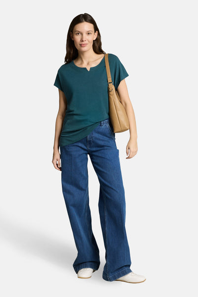 T-shirt à manches courtes vert de Tom Tailor, porté avec un jean ample bleu et un sac à main camel.