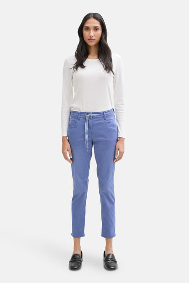Gekleurde blauwe broek van Tom Tailor, met trekkoord in de taille en gedragen met een wit T-shirt met lange mouwen.