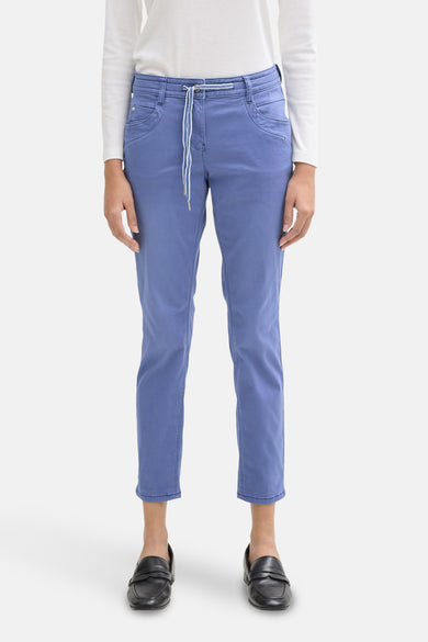 Gekleurde blauwe broek van Tom Tailor, met gestreepte trekkoord in de taille, gedragen met een wit T-shirt en zwarte loafers.