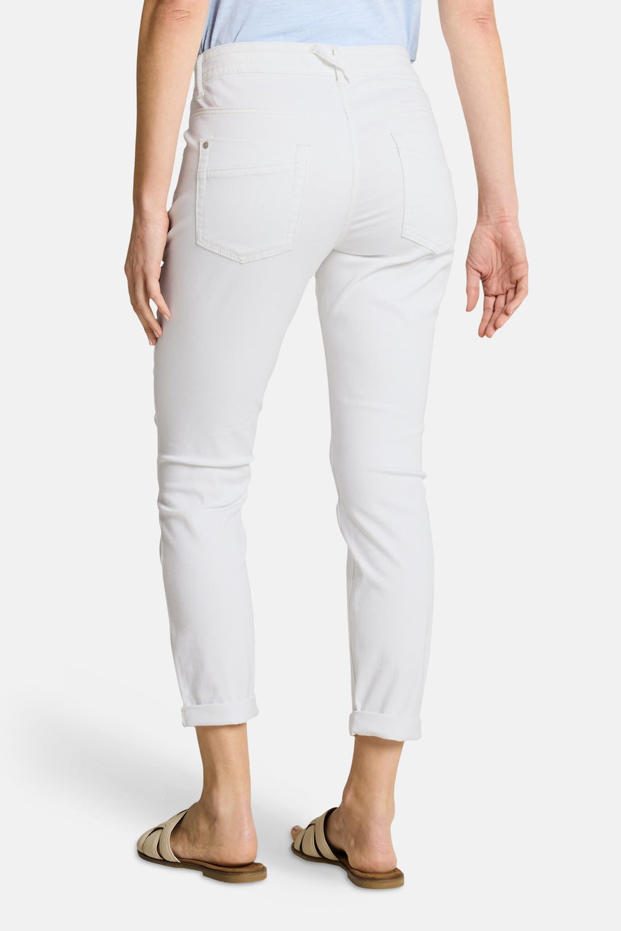 Pantalon coloré blanc de Tom Tailor, vue arrière avec revers aux chevilles, porté avec un t-shirt bleu clair et des sandales beiges.