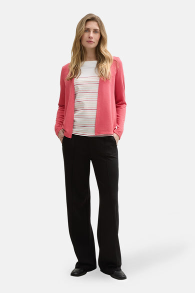 Cardigan rose de Tom Tailor, porté sur un t-shirt rayé, avec un pantalon noir ample.
