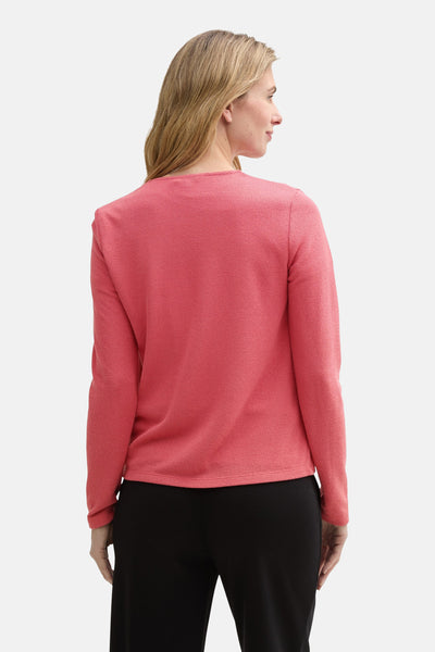 Roze Tom Tailor vest met textuursteek, gedragen met een zwarte broek, achtergezicht.