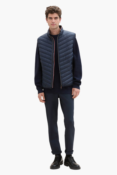 Veste sans manches bleue par Tom Tailor, portée avec un pull et un pantalon bleu marine.
