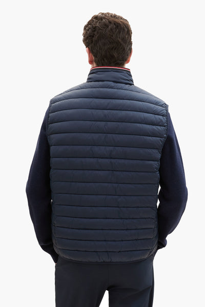 Veste sans manches bleue de Tom Tailor, vue de dos, portée sur un pull bleu marine.