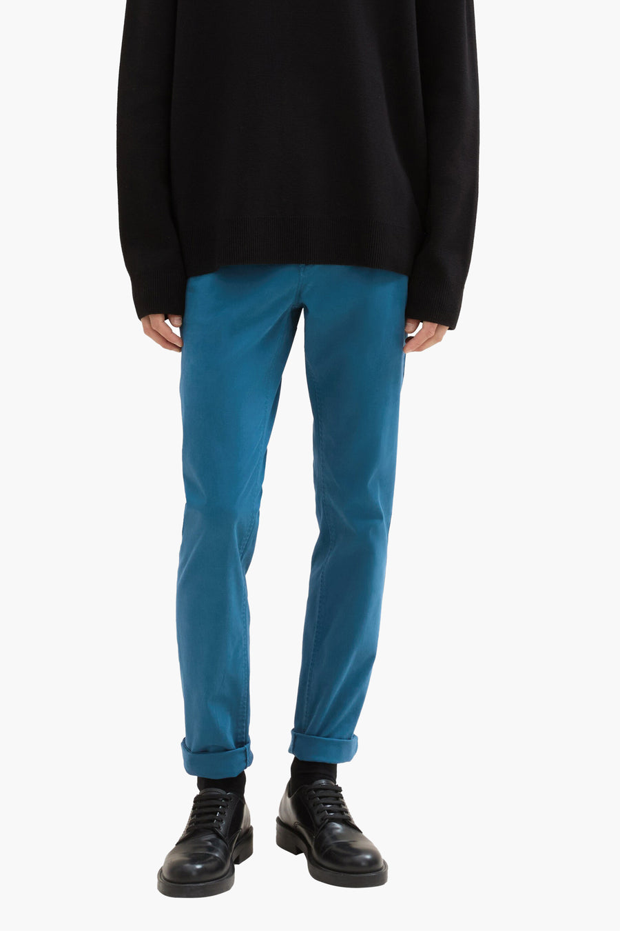 Groene chino van Tom Tailor, gedragen met een zwarte trui en zwarte leren schoenen.