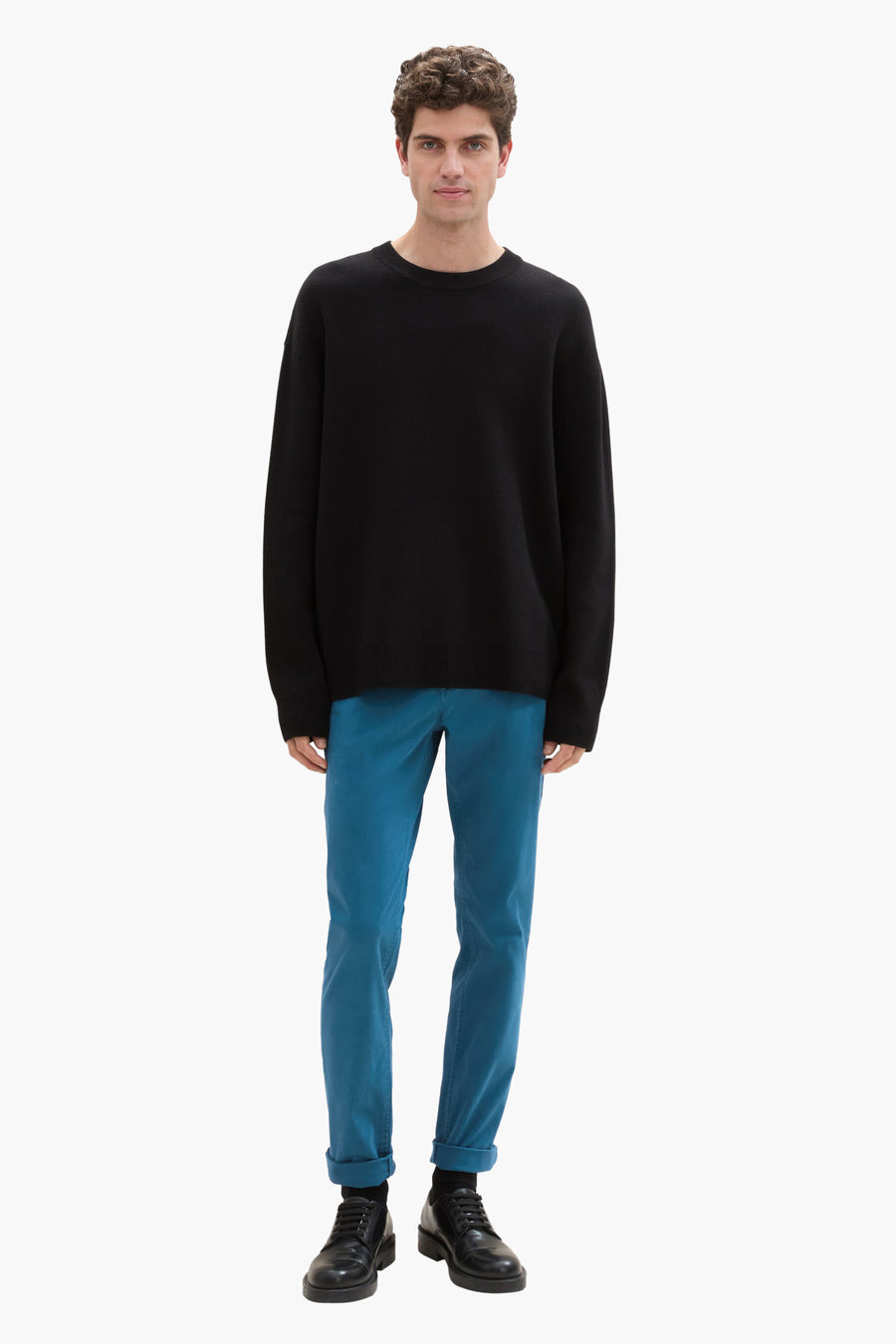 Chino vert de Tom Tailor, porté avec un pull noir et des chaussures en cuir noires.