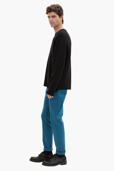 Groene chino van Tom Tailor, gedragen met een zwarte trui en leren schoenen.
