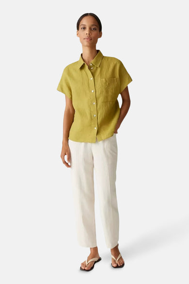 Groen overhemd met korte mouwen van OPUS, gedragen met een witte broek en teenslippers.