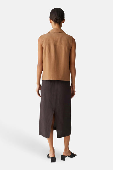 Bruine blazer van OPUS, mouwloos, met een horizontale pas in de bovenrug, gedragen met een zwarte rok.