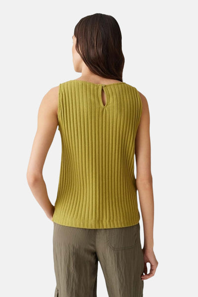 Débardeur vert de OPUS, texture côtelée, avec une petite ouverture au dos, porté avec un pantalon kaki.
