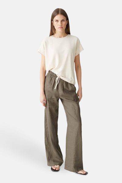 T-shirt écru à manches courtes de OPUS, porté avec un pantalon en lin et des sandales.