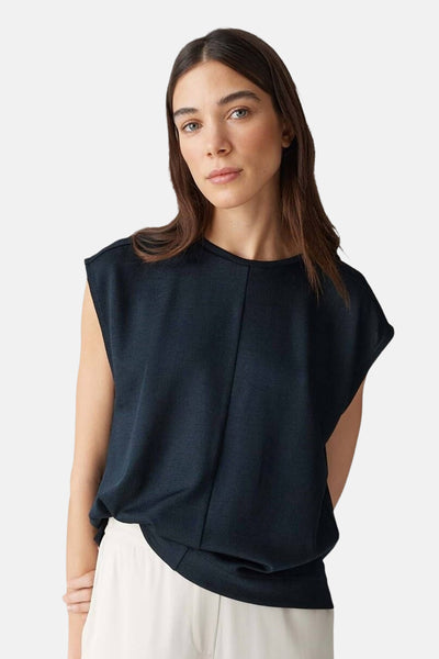 Zwart mouwloos blouse van OPUS, losvallend over een witte broek.
