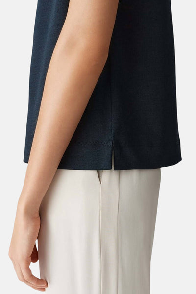 Zwart mouwloos blouse van OPUS, met zijsplitten en gedragen met een beige broek.