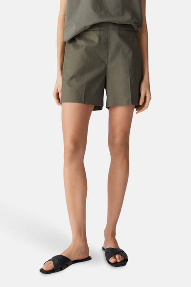 Short kaki par OPUS, porté avec des sandales croisées noires.
