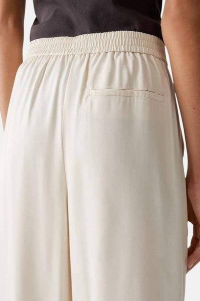 Pantalon écru de OPUS avec taille élastique et poche arrière passepoilée.
