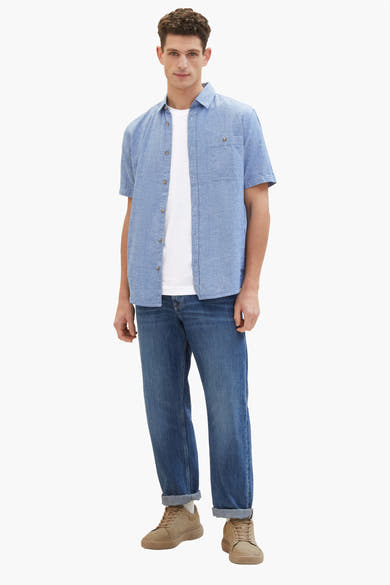 Chemise à manches courtes bleue de Tom Tailor, portée sur un t-shirt blanc et un jean, chaussures couleur sable