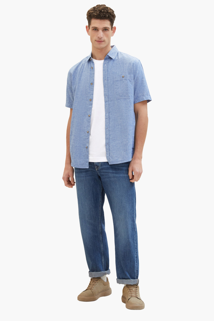 Chemise à manches courtes bleue de Tom Tailor, portée sur un t-shirt blanc et un jean, chaussures couleur sable