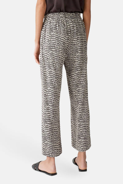 Pantalon imprimé marron par OPUS, avec un motif tacheté noir et une coupe décontractée.