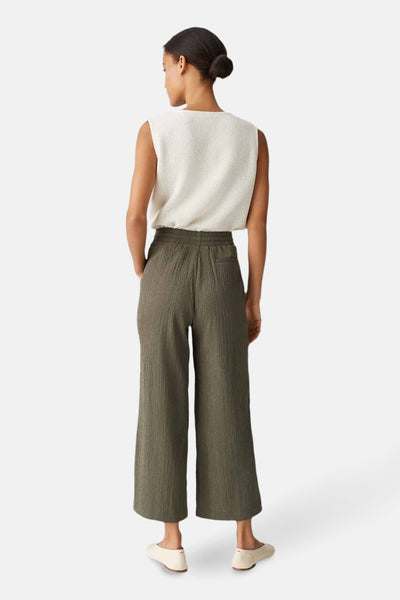 Pantalon kaki tissé, par OPUS, avec des poches latérales et une coupe ample, vu de dos.