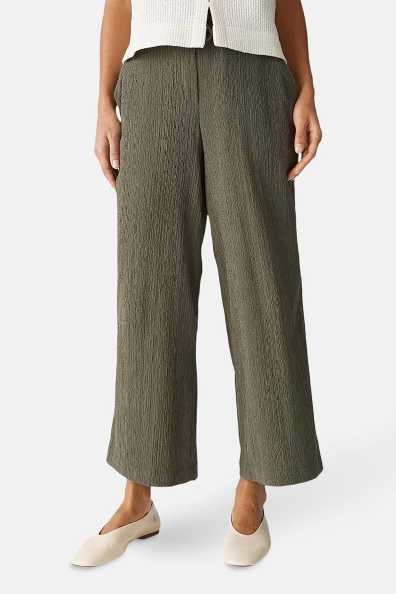 Pantalon kaki froissé de OPUS, coupe ample et chaussures plates crème.
