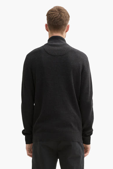 Grijze trui van Tom Tailor, achterkant, met opstaande kraag en gebreide textuur, gedragen met een zwarte broek.