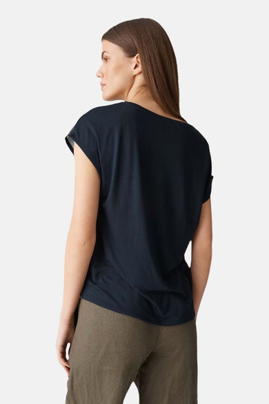 Blouse bleue à manches courtes par OPUS, vue de dos, portée avec un pantalon kaki.