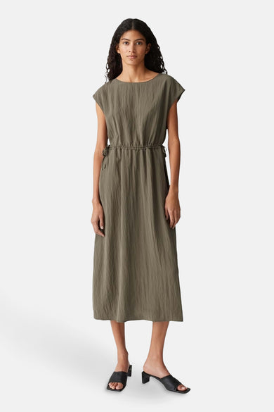 Kaki jurk met korte mouwen van OPUS, met een getailleerde taille en zwarte hakken.