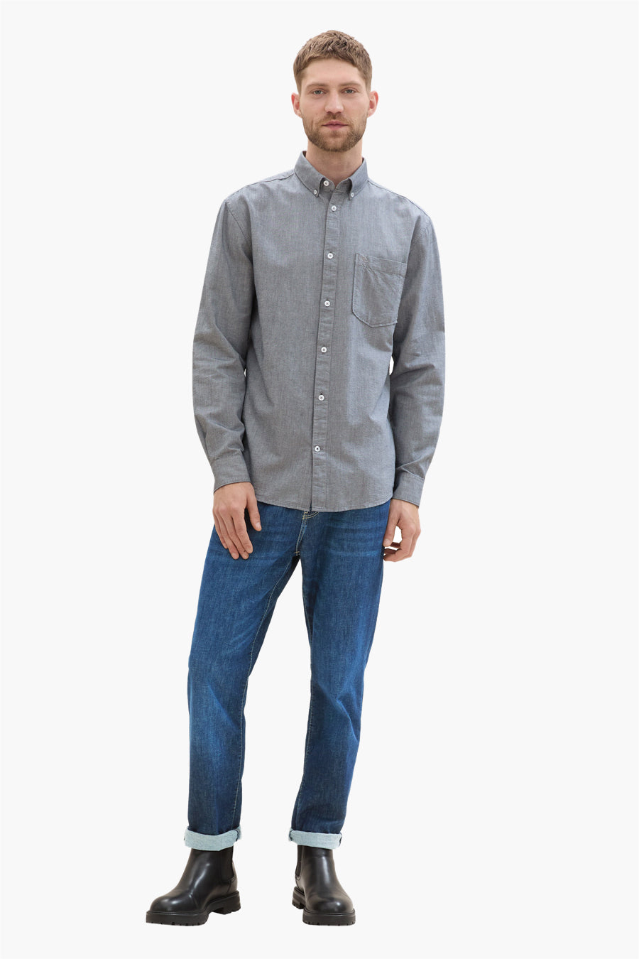 Chemise à manches longues bleue par Tom Tailor, portée avec un jean et des bottines noires.
