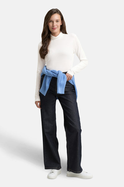 Witte T-shirt met lange mouwen van Tom Tailor, gedragen met een blauwe trui die om de schouders is geknoopt en een wijde jeans.