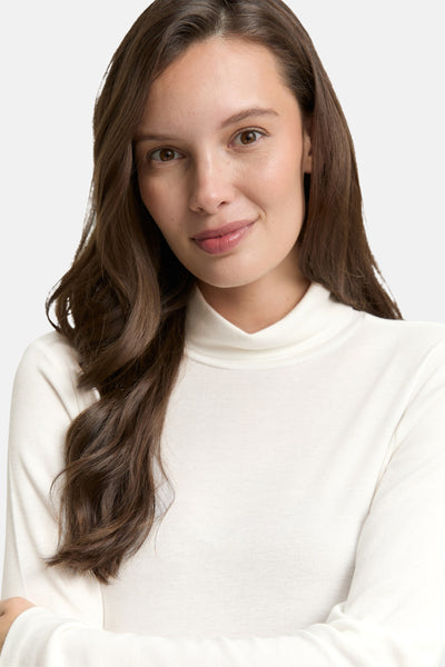 T-shirt à manches longues blanc de Tom Tailor, en maille côtelée, porté par une femme aux cheveux longs.
