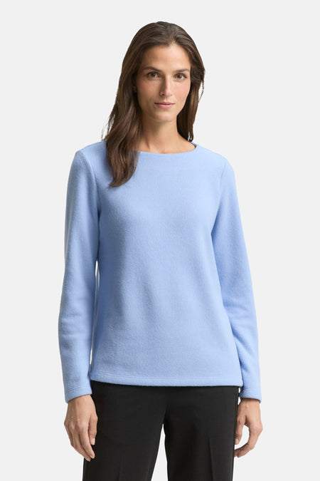 Ronde hals trui blauw van Tom Tailor, gedragen met een effen zwarte broek.