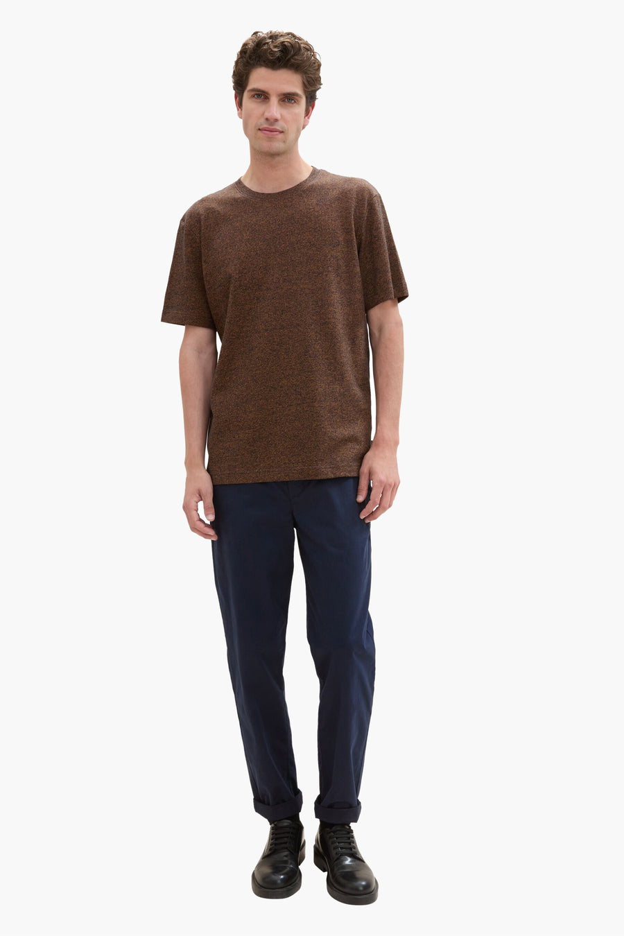 Blauw T-shirt met korte mouwen van Tom Tailor, gedragen met een opgerolde marineblauwe broek en zwarte schoenen.