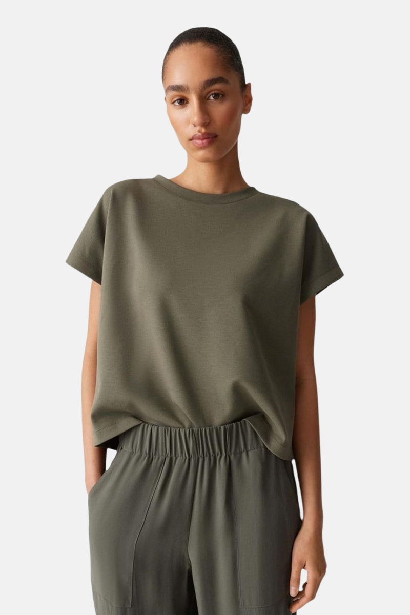 Sweat vert par OPUS, porté avec un pantalon vert à taille élastique, sur fond uni.