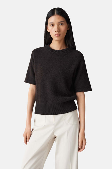 Pull brun à manches courtes par OPUS, porté avec un pantalon de couleur crème.