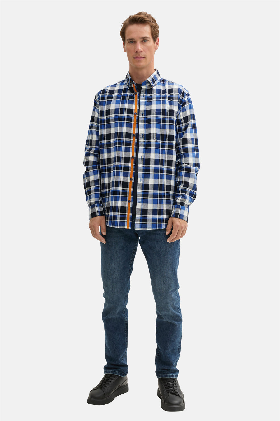 Blauw geruit overhemd met lange mouwen van Tom Tailor, met een oranje bies aan de voorkant, gedragen met een spijkerbroek.
