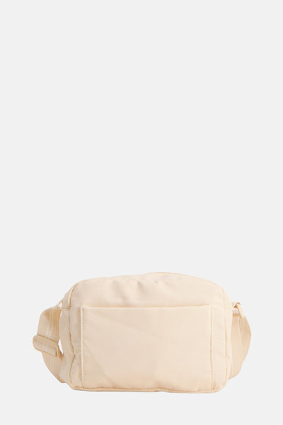 Sac à main beige de OPUS avec une poche avant et une bandoulière assortie.