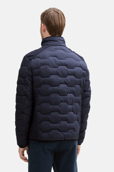 Veste courte bleue de Tom Tailor, matelassée avec motif géométrique, détail en maille texturée sur le haut du dos.