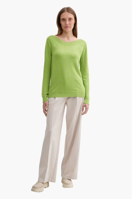 Groene trui met ronde hals van Tom Tailor, gedragen met een wijde beige broek en sleehakken.