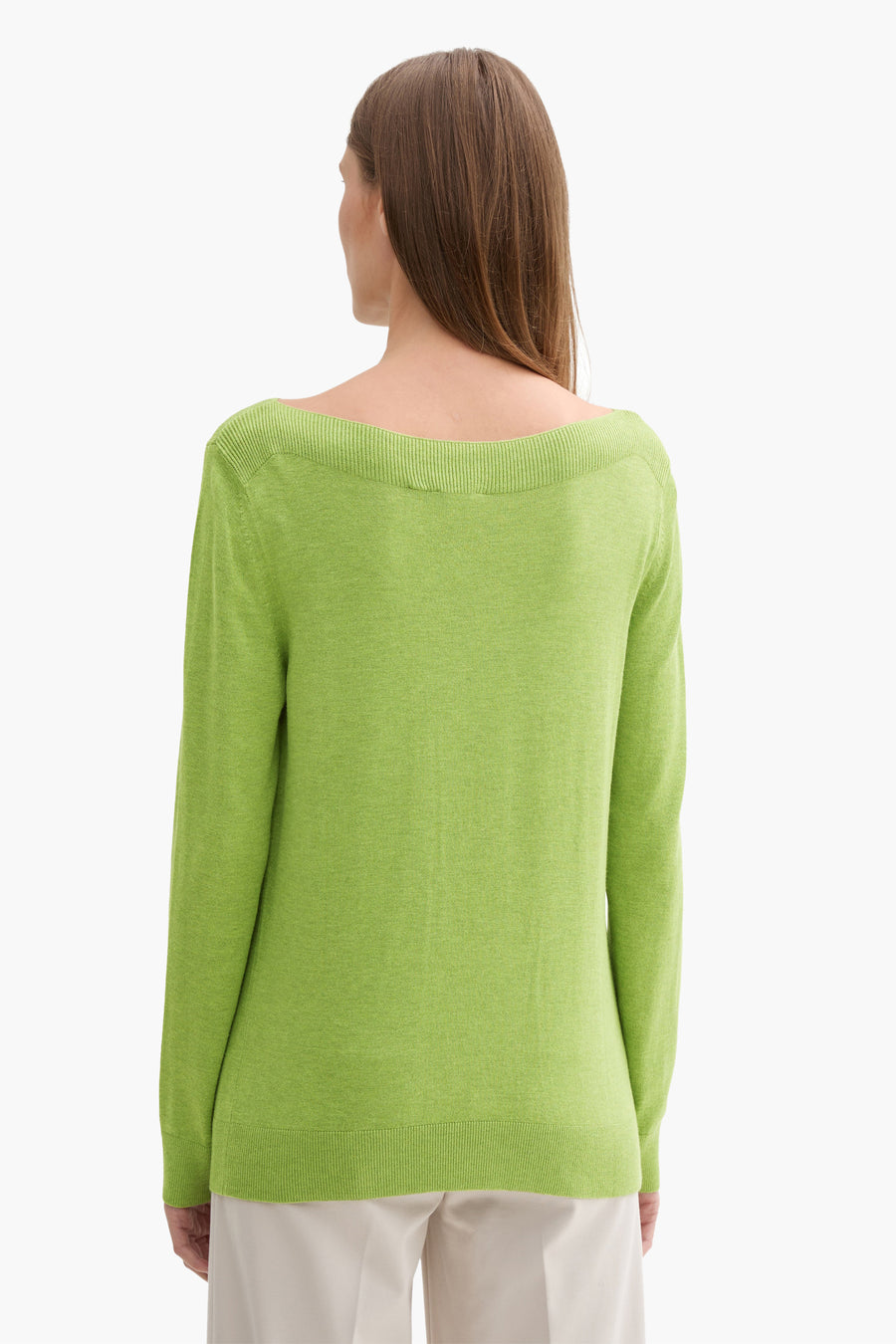 Groene trui met ronde hals van Tom Tailor, van achteren gezien, gedragen met een witte broek.