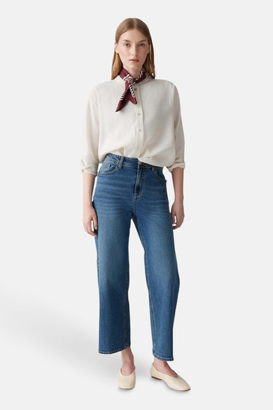 Chemisier écru à manches longues par OPUS, porté avec un foulard à rayures bordeaux et un jean.
